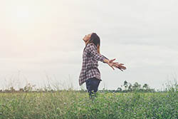 Freedom happy girl feeling alive and free in nature breathing clean and fresh air. showing happiness with arms raised up.